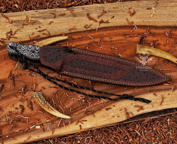 Handmade big dagger with black Micarta handle on wooden background