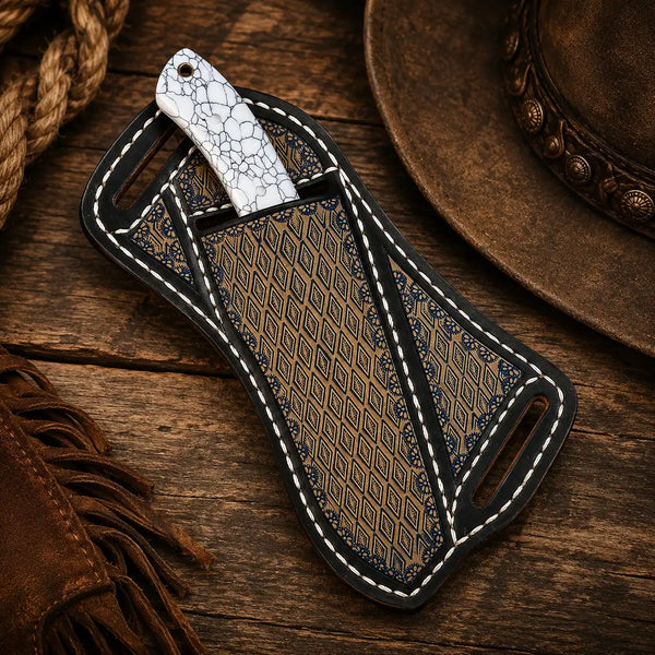 Cowboy knife with white crackle-pattern handle in an ornate leather sheath on a rustic wooden Western background