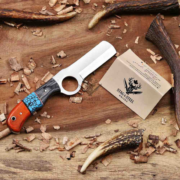 Knife with a branded sheath on a wooden surface with antlers and wood shavings.