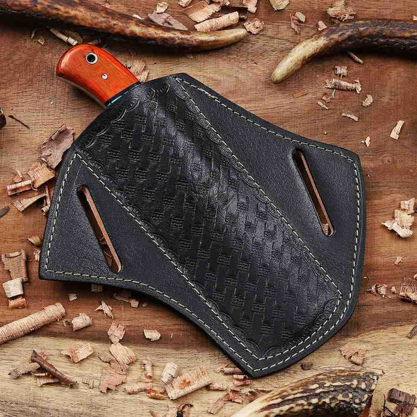 Black leather axe sheath with orange handle on a wooden background