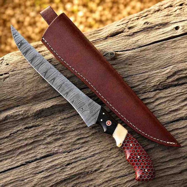 Knife with a red honeycomb handle and leather sheath on wooden surface