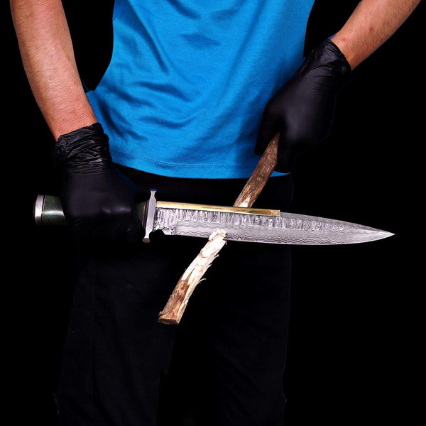 Handmade Damascus Arkansas toothpick bowie knife held in hand cutting the firewood