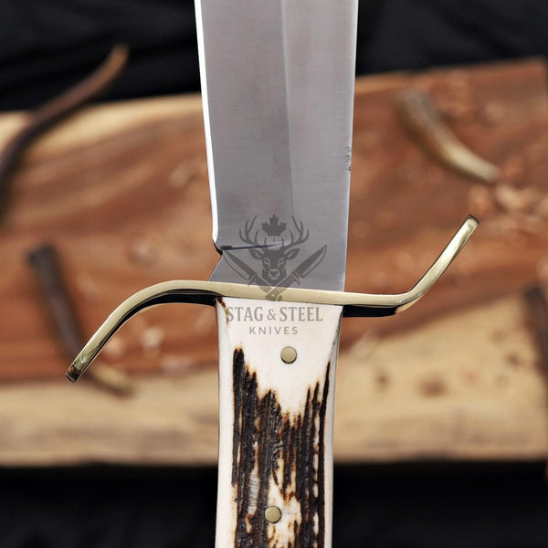 Brass S-guard and stag antler handle on a D2 bowie knife