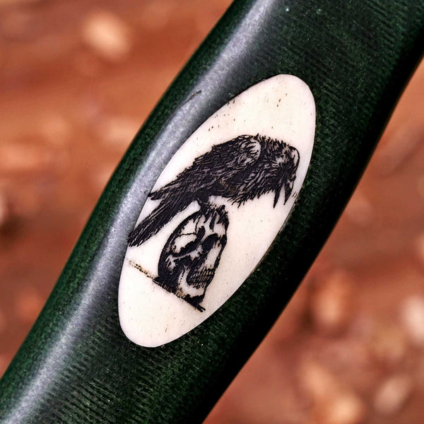 Hand-engraved camel bone scrimshaw inlay of a crow on a skull