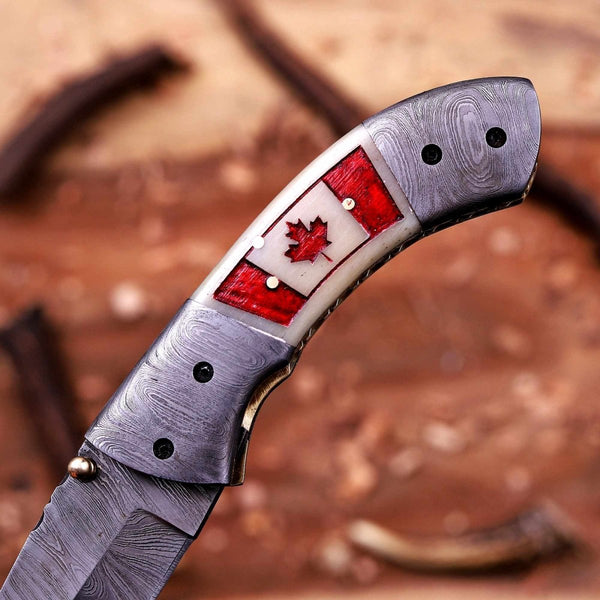 Close-up of Canada flag camel bone handle on handmade folding knife