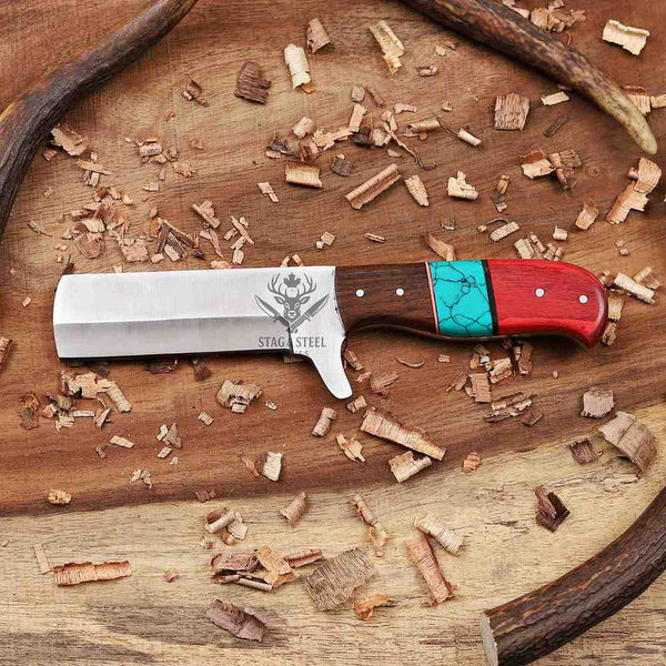 Knife with a red and turquoise handle on a wooden surface with wood shavings