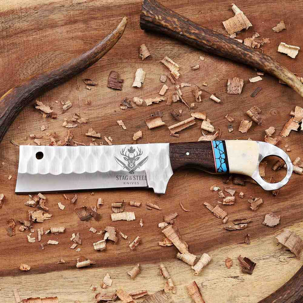 Knife with wooden handle and deer head design on a wooden surface with antlers and wood shavings.