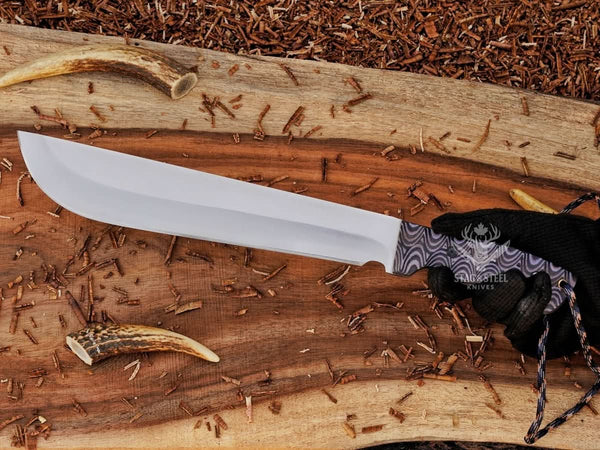 D2 steel machete knife with Grey Micarta handle shown in hand for grip, size, and satin blade detail