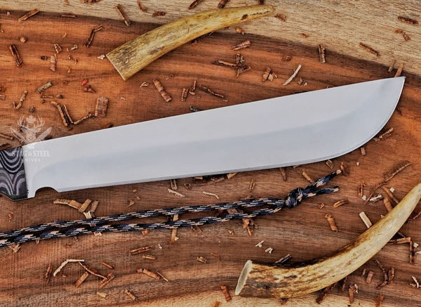 Close-up of satin D2 steel machete blade showing cutting edge, blade profile, and handmade finish