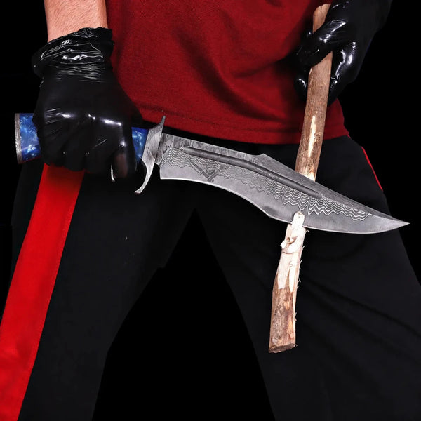 Damascus finger guard bowie knife cutting a wooden branch in a strength test