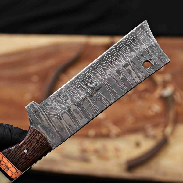 Damascus steel knife blade with a wooden handle on a wooden surface