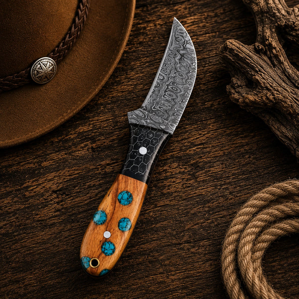 Full profile of a handmade curved skinning knife with raindrop Damascus blade