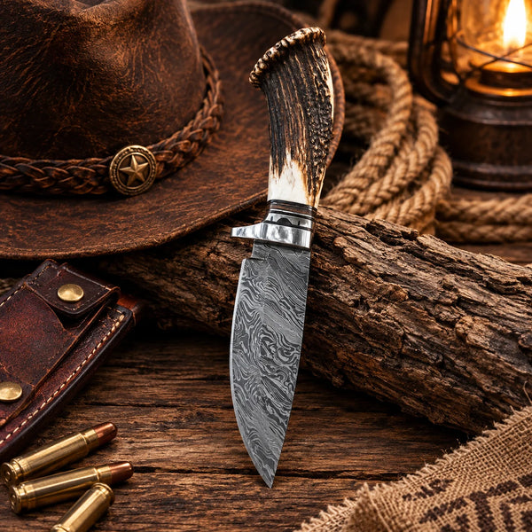 Hand forged Damascus hunting knife with deer antler crown handle against a log Copy