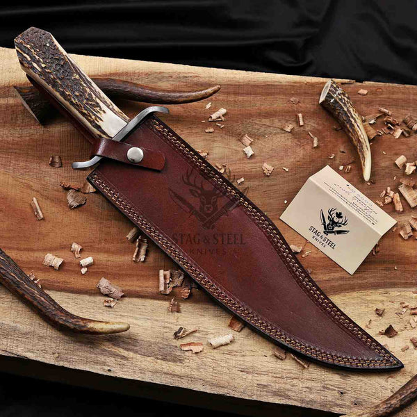 Juan Padillo Damascus Bowie knife in a brown tooled leather sheath beside a Stag Steel branded Care Card