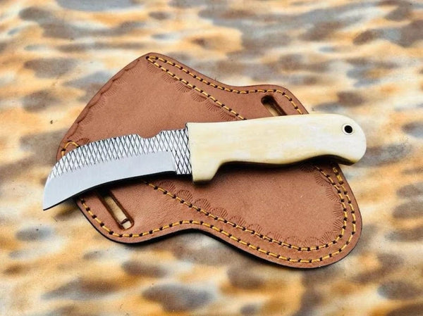 Polished cream bone handle with pinned construction on a rasp steel hawkbill knife