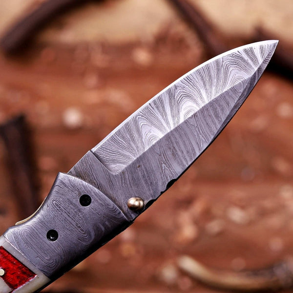 Close-up of real Damascus steel folding knife blade with layered 1095 and 15N20 pattern