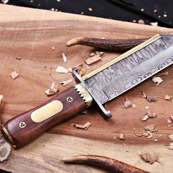 A custom handcrafted knife with a Damascus steel blade, a brass bolster, and a dark brown wooden handle with brass accents, resting on a wooden cutting board with wood shavings.