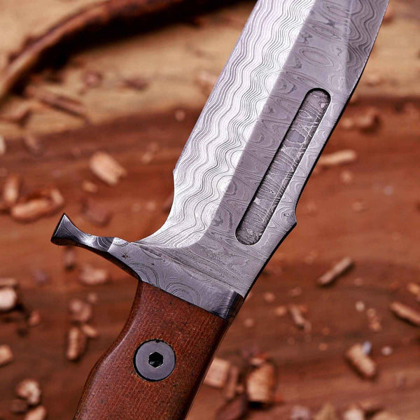 Close-up of VG10 Damascus bowie blade with fuller and forged Damascus guard