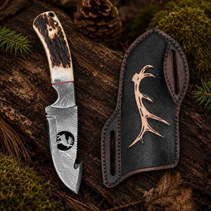 Handmade 8-inch Damascus gut hook hunting knife with a wire-cutting notch, running animal medallion inlay, and cast pine cone resin handle.