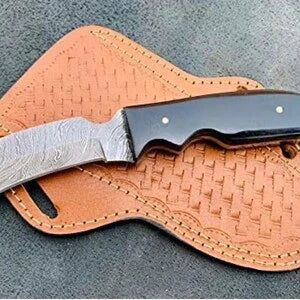 Buffalo horn Damascus hawkbill knife on a tooled cross draw leather sheath