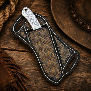 Cowboy knife with white crackle-pattern handle in an ornate leather sheath on a rustic wooden Western background