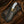 Cowboy Damascus knife with white crackle-pattern handle and decorative leather sheath on a rustic Western background