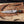 Handmade Cu-Mai bowie knife horizontally laying on wood surface 