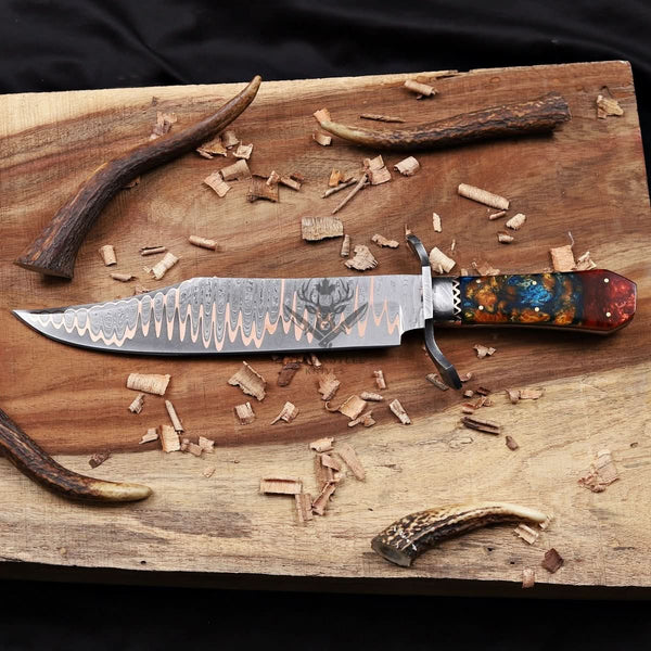 Handmade Cu-Mai bowie knife horizontally laying on wood surface 