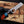 Hand holding a knife with a unique handle design on a wooden surface.