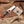 Knife with a branded sheath on a wooden surface with antlers and wood shavings.
