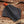 Black leather axe sheath with orange handle on a wooden background