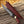 Knife with a red honeycomb handle and leather sheath on wooden surface