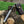 Folding knife with a leather sheath on a wooden surface