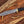 Damascus bowie knife with black handle and brass guard on rustic wood slab