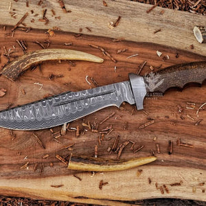 Damascus bowie knife with walnut handle on rustic wood with antlers