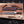 Feather Damascus bowie knife with antler handle beside carved red deer embossed leather sheath