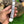 Hand holding a folding knife with a decorative handle against a natural background