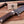 A close-up of a Stag & Steel Knives fixed-blade knife with a patterned steel blade and a textured antler handle, resting on a wooden surface with wood shavings and a brand card.