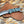A fixed-blade knife with a textured silver blade and a marbled turquoise, green, and black handle, resting on a brown woven leather sheath over a leopard-print fabric background.