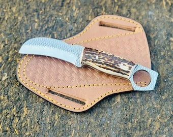 Stag horn ring pommel hawkbill knife in rasp steel on a cross draw leather sheath