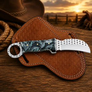  Hawkbill knife with a resin handle, resting on a Pancake leather sheath with rasp steel blade