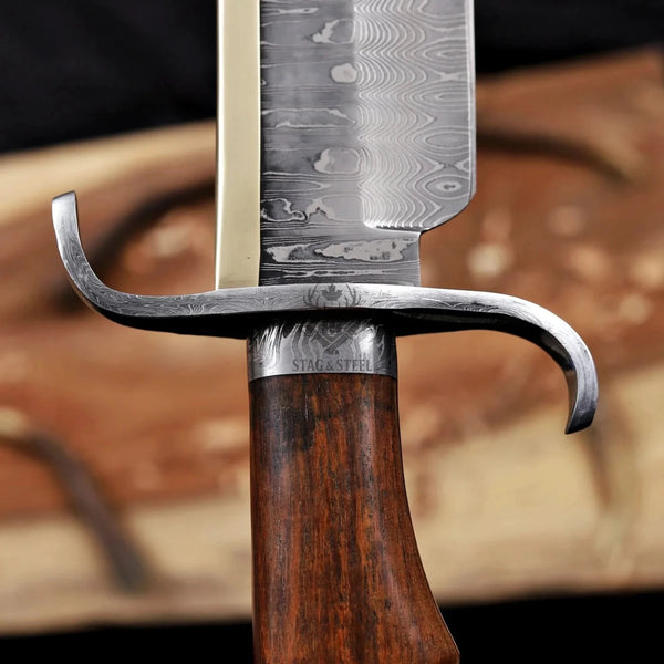 alamo musso damascus bowie knife rosewood handle guard close up curved steel guard and blade transition