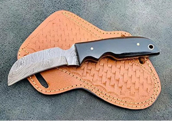 Flowing Damascus layer pattern on a handmade hawkbill knife blade