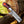 Knife with a red and blue handle on a wooden log
