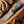Knife with a wooden handle on a wooden surface next to rope