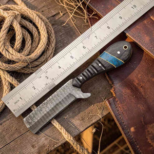 Knife with a wooden handle on a wooden surface next to a ruler and rope.