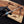 Hand holding a pocket knife with wooden handle and metal blade, against a blurred background.