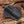 Black leather sheath with wooden handle on a wooden background