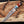 Copper damascus bowie knife with a detailed blade on a wooden surface with wood shavings.