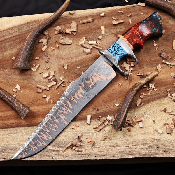 Copper damascus bowie knife with a detailed blade on a wooden surface with wood shavings.